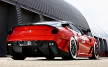 Заряженный красный Ferrari 599 XX с карбоновыми обвесами на гоночном треке у боксов